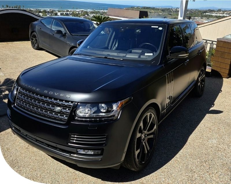 professional car detailer inspecting vehicle paint condition before detailing